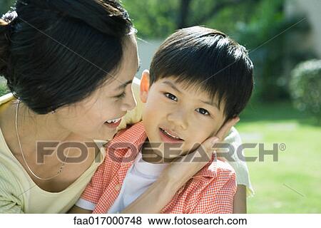 Mother and son, woman with hand on boy's cheek, boy looking at camera View Large Photo Image Stock Photo - Mother and son, woman with hand on boy's cheek, boy looking at camera. Fotosearch