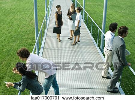 People standing in small groups on walkway, high angle view View Large Photo Image Stock Image - People standing in small groups on walkway, high angle view. Fotosearch