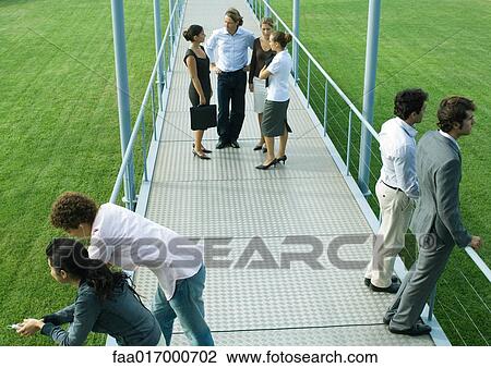 People standing in small groups on walkway, high angle view View Large Photo Image Stock Image - People standing in small groups on walkway, high angle view. Fotosearch
