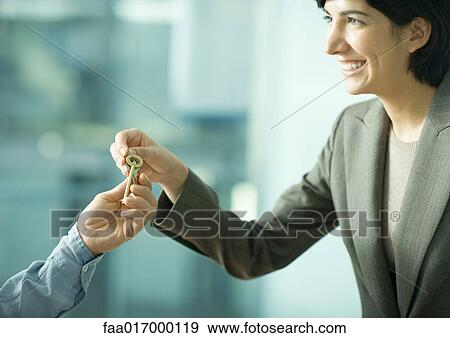 Professional woman handing man set of keys View Large Photo Image Stock Photo - Professional woman handing man set of keys. Fotosearch