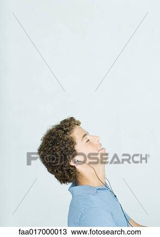 Teenage boy listening to earphones View Large Photo Image Stock Image - Teenage boy listening to earphones. Fotosearch