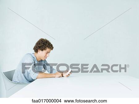 Picture - Teenage boy using cell phone. Fotosearch