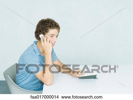 Picture - Teenage boy using cell phone. Fotosearch