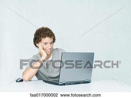 Teenage boy using laptop View Large Photo Image Stock Image - Teenage boy using laptop. Fotosearch