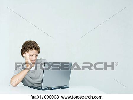 Teenage boy using laptop View Large Photo Image Stock Image - Teenage boy using laptop. Fotosearch