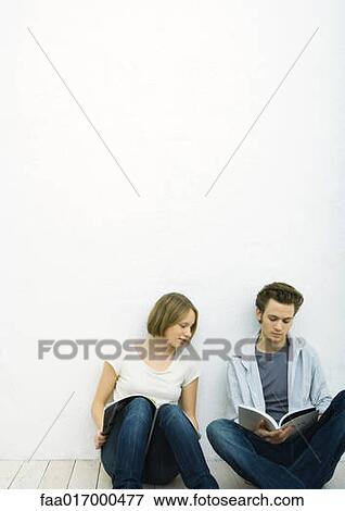 Teenage girl and young man sitting on floor with books, girl looking over at man's book View Large Photo Image Stock Photo - Teenage girl and young man sitting on floor with books, girl looking over at man's book. Fotosearch