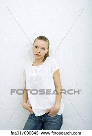 Teenage girl leaning against wall, looking at camera, portrait View Large Photo Image Stock Image - Teenage girl leaning against wall, looking at camera, portrait. Fotosearch