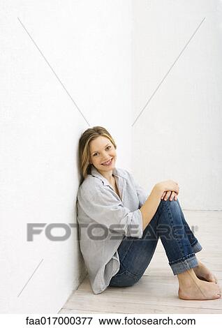 Teenage girl sitting on floor, smiling at camera, portrait View Large Photo Image Stock Photo - Teenage girl sitting on floor, smiling at camera, portrait. Fotosearch