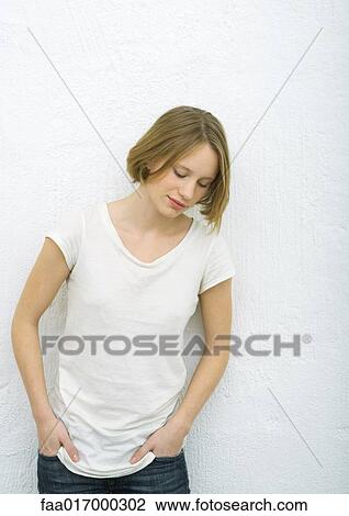 Teenage girl standing with hands in pockets, looking down, portrait View Large Photo Image Stock Image - Teenage girl standing with hands in pockets, looking down, portrait. Fotosearch