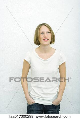 Teenage girl standing with hands in pockets, looking up, portrait View Large Photo Image Stock Photo - Teenage girl standing with hands in pockets, looking up, portrait. Fotosearch