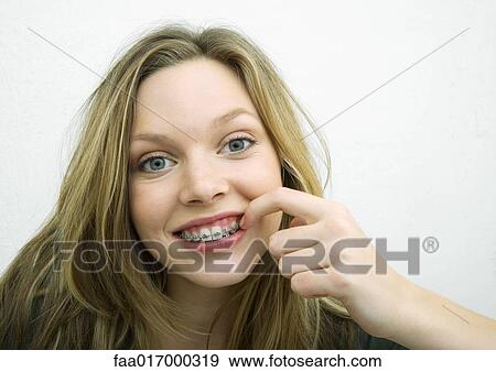 Teenage girl touching braces, portrait View Large Photo Image Stock Photo - Teenage girl touching braces, portrait. Fotosearch