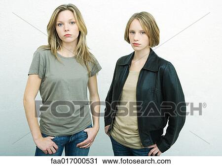 Teenage girls standing side by side with hands on hips, looking at camera, portrait View Large Photo Image Stock Image - Teenage girls standing side by side with hands on hips, looking at camera, portrait. Fotosearch