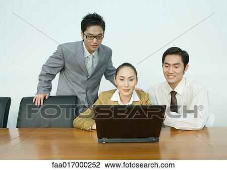 Three business associates using laptop View Large Photo Image Stock Image - Three business associates using laptop. Fotosearch