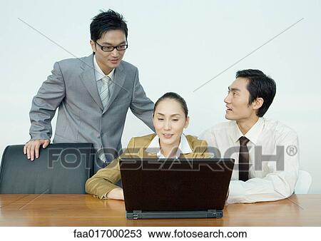 Three business associates using laptop View Large Photo Image Stock Image - Three business associates using laptop. Fotosearch