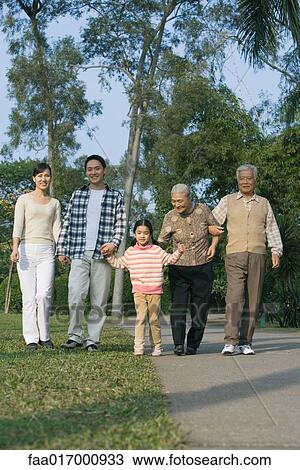 Stock Image - Three generation family walking in park. Fotosearch