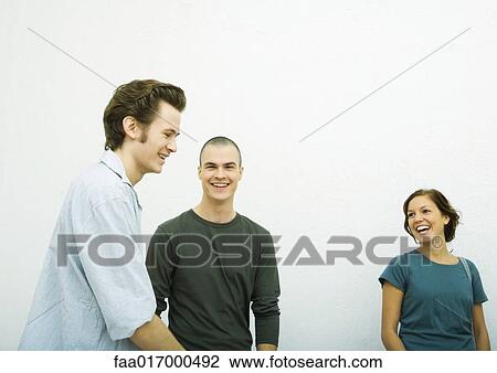 Three young adults, laughing, white background View Large Photo Image Stock Image - Three young adults, laughing, white background. Fotosearch