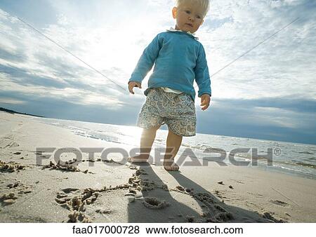 Toddler standing on beach, low angle view View Large Photo Image Stock Photo - Toddler standing on beach, low angle view. Fotosearch