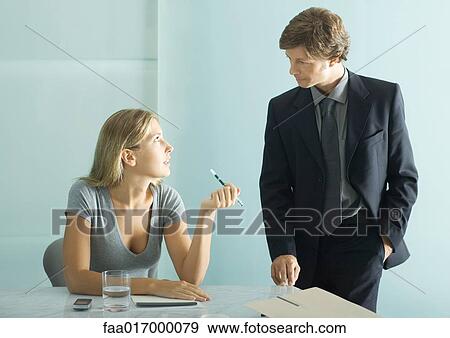 Stock Photo - Two business colleagues having conversation. Fotosearch