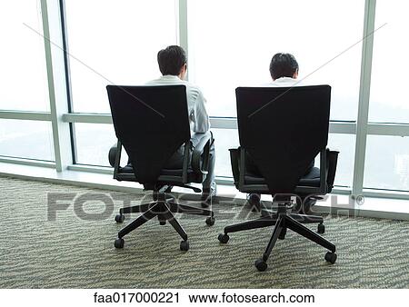 Two businessmen sitting in armchairs by window, rear view View Large Photo Image Stock Image - Two businessmen sitting in armchairs by window, rear view. Fotosearch