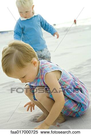 Stock Photography - Two toddlers playing on beach. Fotosearch