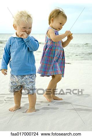 Two toddlers standing on beach View Large Photo Image Picture - Two toddlers standing on beach. Fotosearch