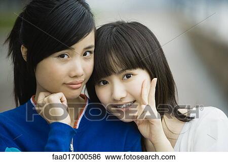 Two young adult female friends, one making "v" sign with fingers View Large Photo Image Stock Photograph - Two young adult female friends, one making "v" sign with fingers. Fotosearch
