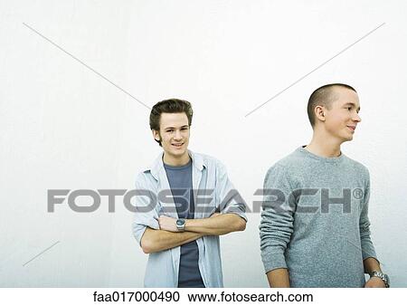 Two young adult men, one looking at camera, the other looking away View Large Photo Image Stock Image - Two young adult men, one looking at camera, the other looking away. Fotosearch