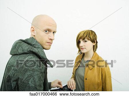 Two young adults, looking at camera View Large Photo Image Stock Photograph - Two young adults, looking at camera. Fotosearch