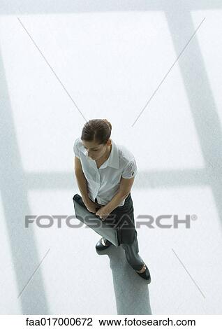 Woman holding briefcase, high angle view View Large Photo Image Stock Image - Woman holding briefcase, high angle view. Fotosearch