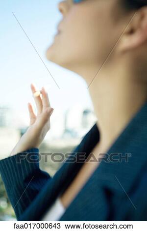 Stock Image - Woman smoking cigarette, close-up. Fotosearch