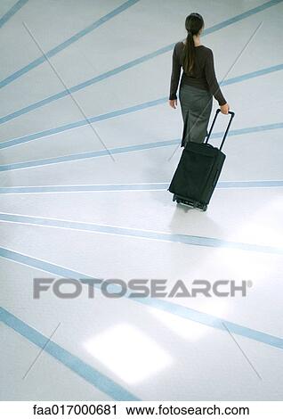 Woman walking with suitcase, high angle rear view View Large Photo Image Stock Image - Woman walking with suitcase, high angle rear view. Fotosearch
