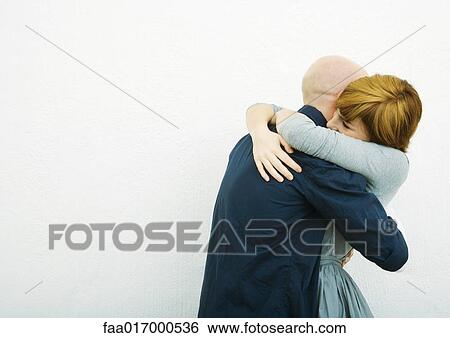 Stock Photograph - Young couple embracing, side view. Fotosearch