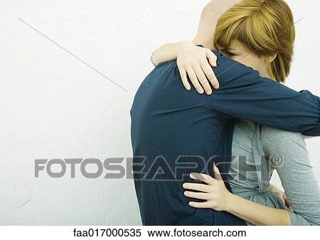 Stock Photography - Young couple embracing, side view. Fotosearch