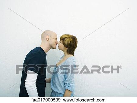 Stock Photo - Young couple kissing, side view. Fotosearch
