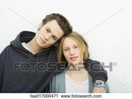 Young couple leaning against wall, looking at camera, portrait View Large Photo Image Stock Image - Young couple leaning against wall, looking at camera, portrait. Fotosearch