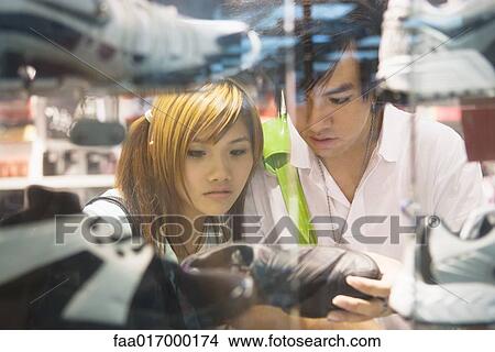 Young couple looking at sports shoes in store View Large Photo Image Picture - Young couple looking at sports shoes in store. Fotosearch