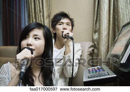 Young couple singing karaoke View Large Photo Image Stock Photo - Young couple singing karaoke. Fotosearch