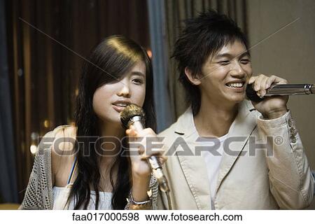 Young couple singing karaoke View Large Photo Image Stock Photo - Young couple singing karaoke. Fotosearch
