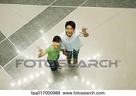 Young couple standing on star pattern, looking up at camera, high angle view View Large Photo Image Stock Photo - Young couple standing on star pattern, looking up at camera, high angle view. Fotosearch