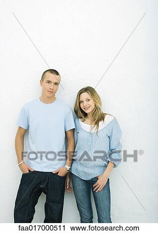 Young couple standing side by side, looking at camera, portrait, white background View Large Photo Image Stock Image - Young couple standing side by side, looking at camera, portrait, white background. Fotosearch