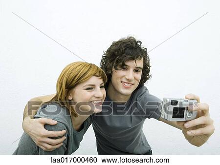 Stock Image - Young couple taking photo together. Fotosearch