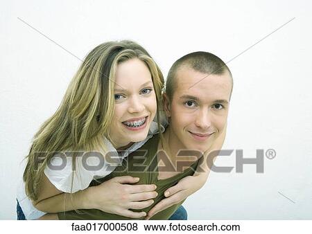 Young couple, teenage girl on young man's back, white background View Large Photo Image Stock Photo - Young couple, teenage girl on young man's back, white background. Fotosearch