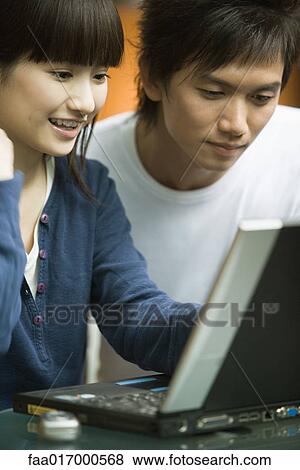 Young couple using laptop View Large Photo Image Stock Photo - Young couple using laptop. Fotosearch
