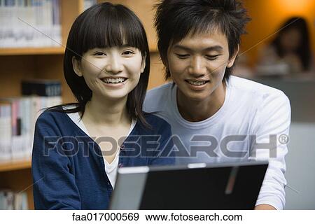 Young couple using laptop View Large Photo Image Stock Photo - Young couple using laptop. Fotosearch
