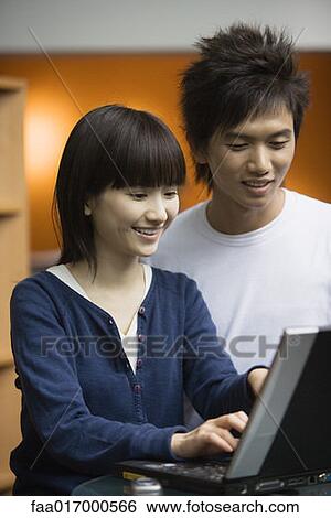 Stock Photograph - Young couple using laptop. Fotosearch
