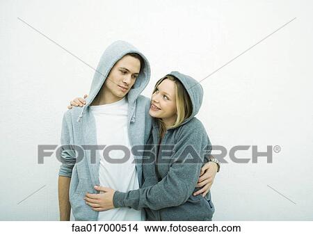 Picture - Young couple wearing hooded sweatshirts. Fotosearch