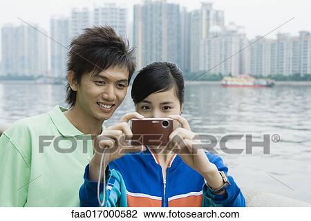Young couple, woman taking photo View Large Photo Image Stock Image - Young couple, woman taking photo. Fotosearch