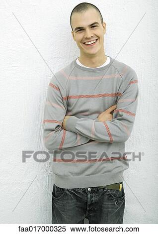 Young man, standing with arms crossed, portrait View Large Photo Image Stock Photography - Young man, standing with arms crossed, portrait. Fotosearch