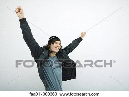 Young man standing with arms out, white background View Large Photo Image Stock Image - Young man standing with arms out, white background. Fotosearch