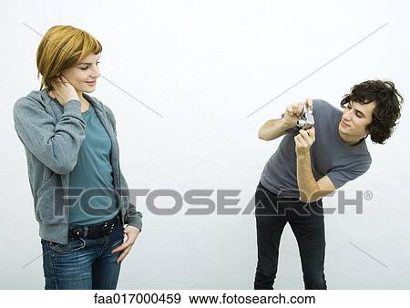 Stock Photo - Young man taking photo of young woman. Fotosearch